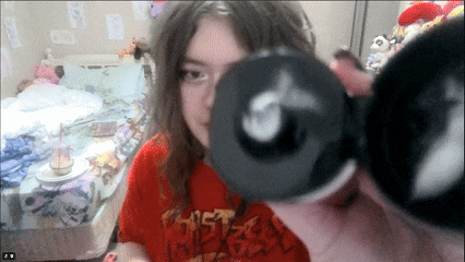 a girl wearing a red shirt that says ' ghost rider ' on it