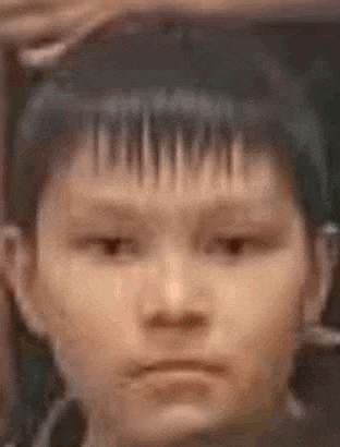 a close up of a child 's face with a shaved head and a shaved forehead .