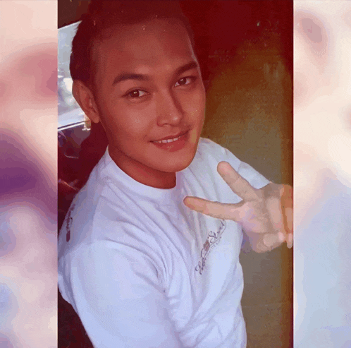 a young man wearing a white shirt that says ' hawaii ' on it