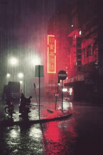 a sign that says ' no entry ' is lit up in the rain