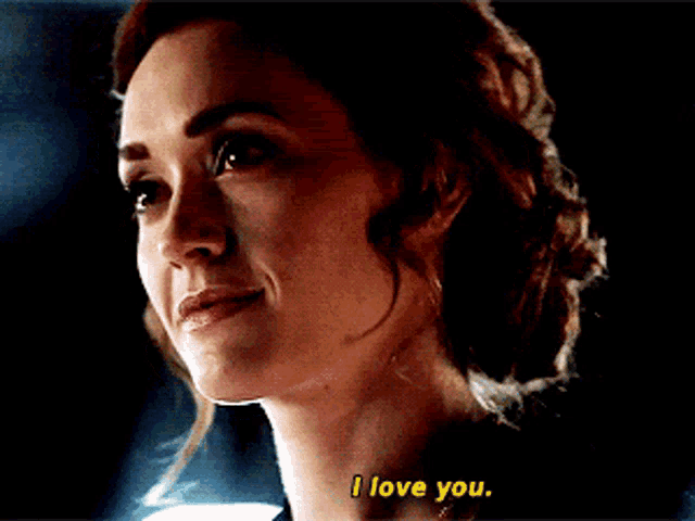 a woman smiles and says i love you in yellow letters