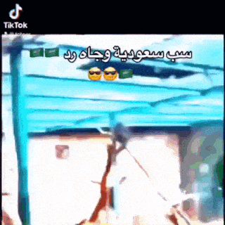 a man is standing under a blue canopy with arabic writing on it