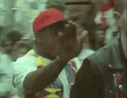 a man wearing a red hat is holding his hand to his face