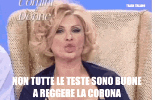 a woman is sitting in a chair with the words non tutte le teste sono buone a reggere la corona on the bottom