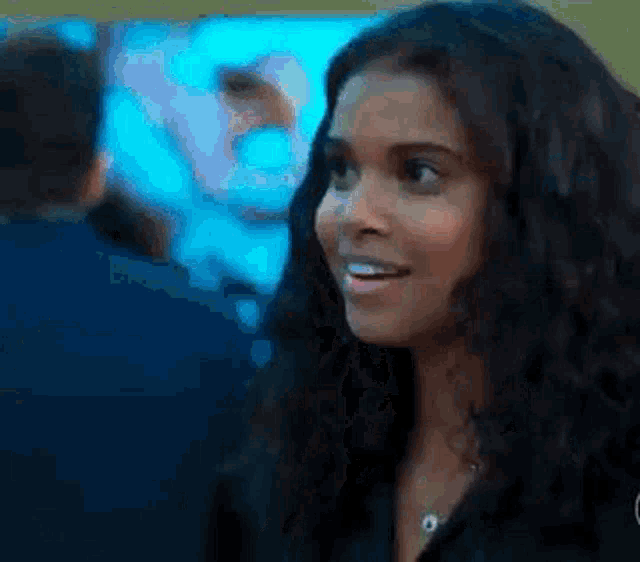 a close up of a woman 's face with a blurry background and a man in the background .