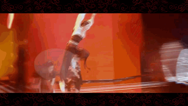 a blurred image of a woman doing a handstand in front of a red wall
