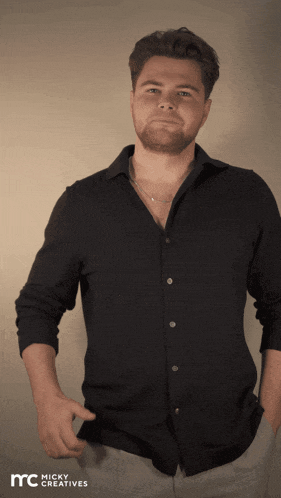 a man wearing a black shirt with micky creatives written on the bottom right