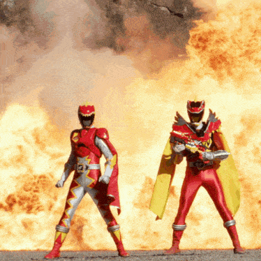 two red power rangers are standing in front of a large fire