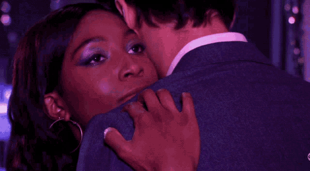 a man and a woman are hugging in a dark room