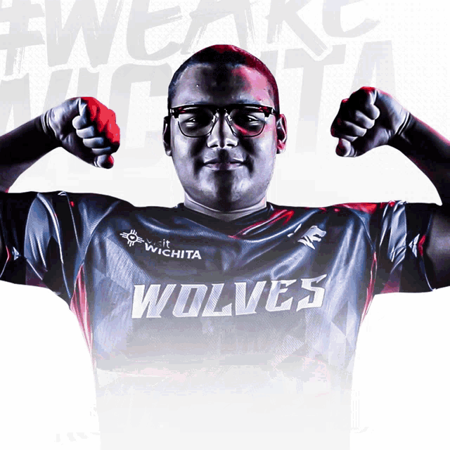 a man wearing a shirt that says wolves flexes his muscles