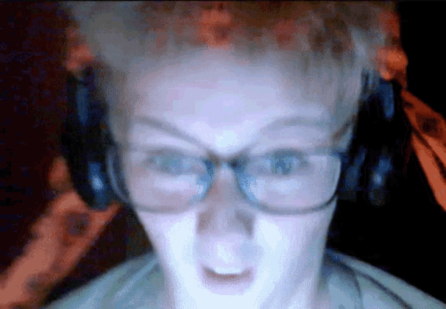 a person wearing glasses and headphones looks surprised