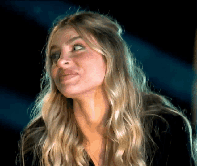 a close up of a woman 's face with a dark background