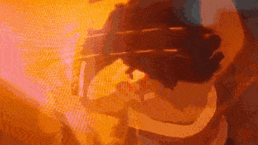 a close up of a person holding a sword in a dark room with a blurred background .