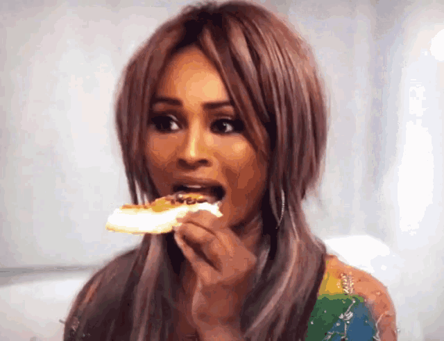 a woman is eating a piece of pizza with a fork .