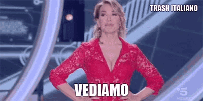 a woman in a red dress is standing on a stage with her hands on her hips and says vediamo
