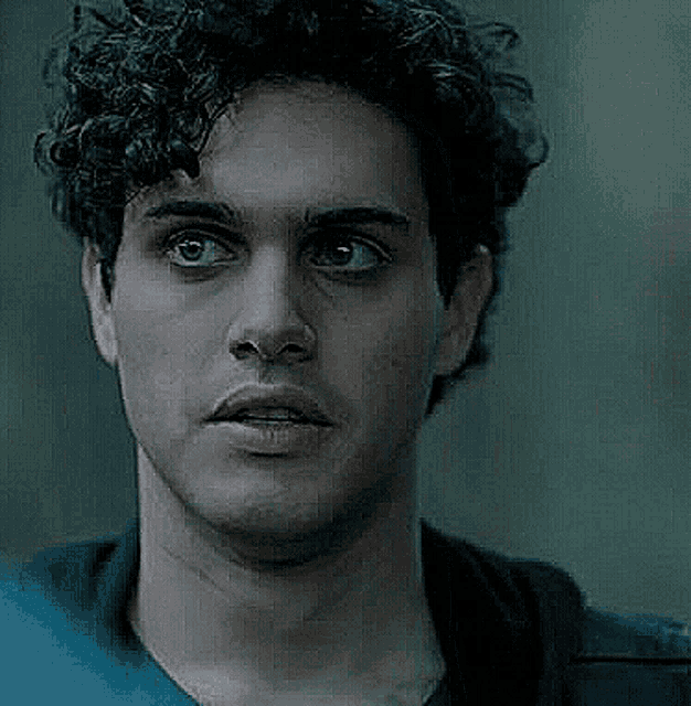 a close up of a man 's face with curly hair