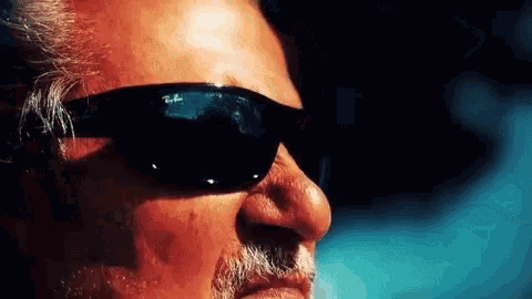 a man with a beard wearing ray ban sunglasses