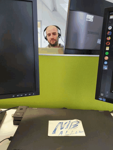 a man wearing headphones sits in front of a samsung computer