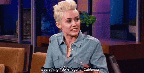 a woman in a denim shirt is sitting on a couch talking to a microphone .