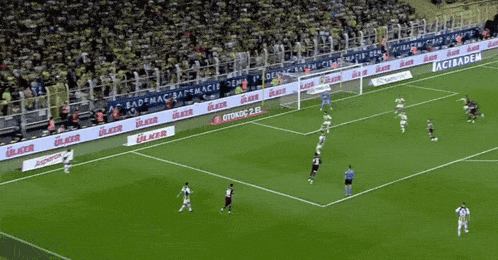 a soccer game is being played on a field with a banner that says ulker on it