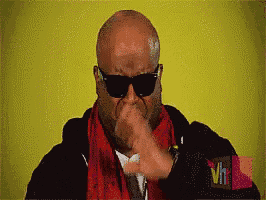 a man wearing sunglasses and a red scarf has a vh logo on his sleeve