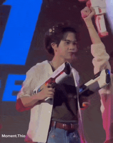 a man is holding a toy gun in front of a blue letter f