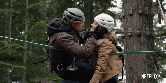 a man is carrying a woman in his arms with a netflix logo behind them