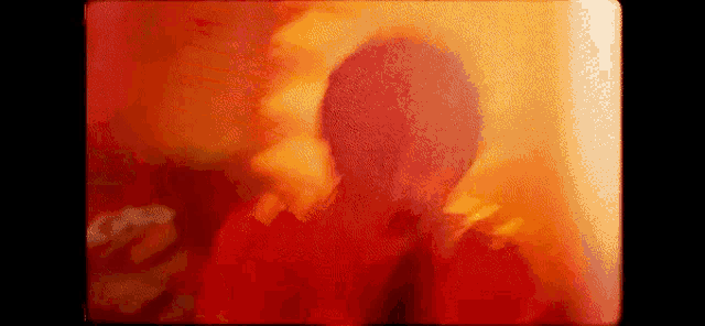 a close up of a person 's face in a red and yellow background .