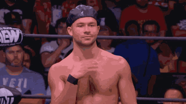 a shirtless man in a wrestling ring with a sign that says dew