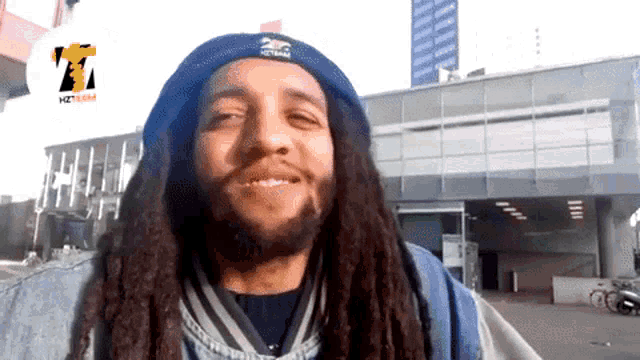 a man with dreadlocks wearing a hat that says hzt team