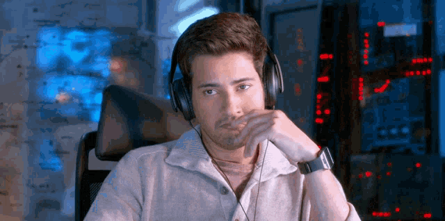 a man wearing headphones sits in front of a monitor