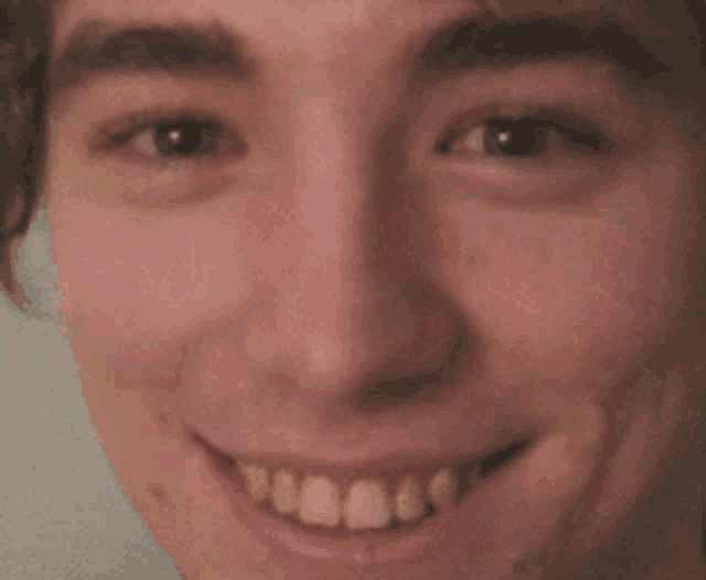 a close up of a man 's face with a smile