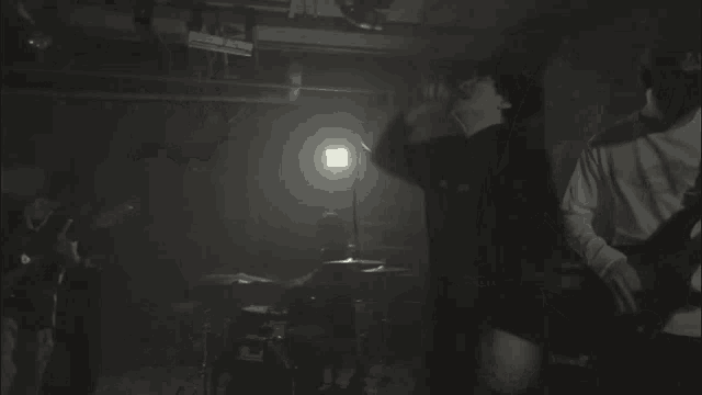 a man is playing a guitar in a dark room with a marshall amp in the background .