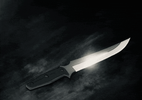 a person is holding a knife in a dark room