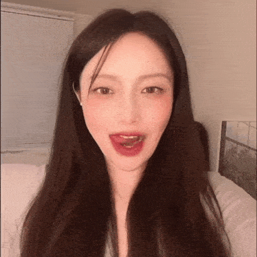 a woman with long hair is making a funny face with her tongue out