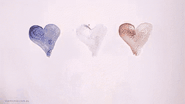 a person is drawing three hearts on a piece of paper with the words #prayfor written below them