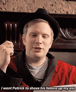 a man wearing a black hat and a red robe says i want patrick to shove his fedora up my ass .