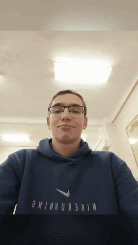 a man wearing glasses and a blue nike shirt