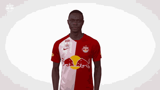 a soccer player wearing a red and white jersey with a red bull on it
