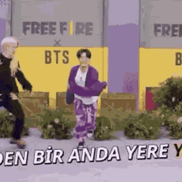 two men are dancing in front of a free fire sign .