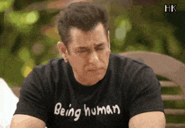 a man wearing a black shirt that says being human on it