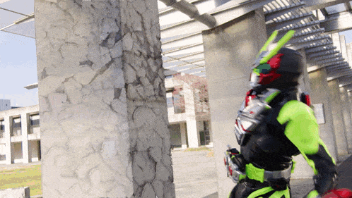 a person in a green and black costume is standing next to a pillar