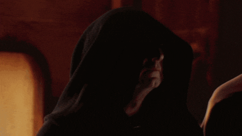 a man with a hood on his head is looking at something