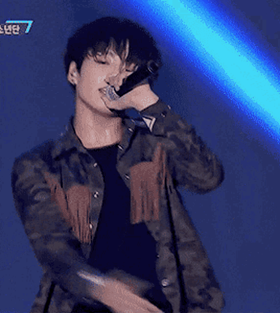 a man is singing into a microphone with the number 7 on the bottom right