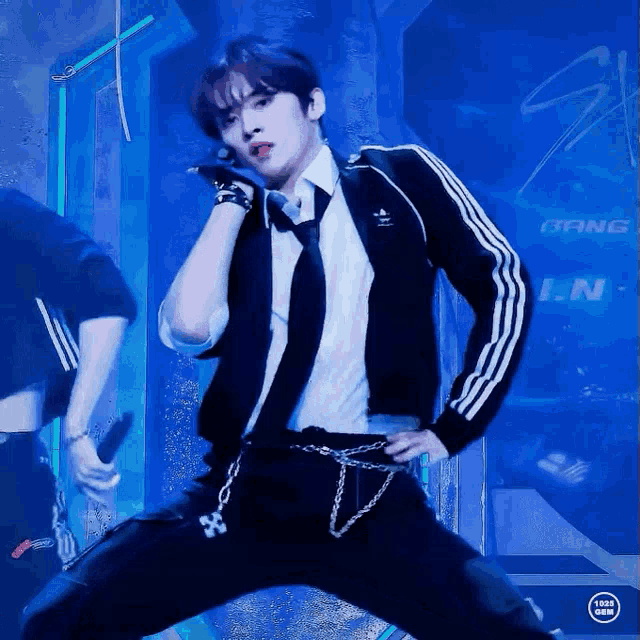 a man in a suit and tie is dancing in front of a blue background that says bang