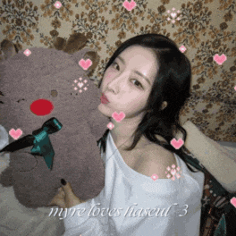 a woman is holding a stuffed reindeer with hearts around her and the words myre loves haseul 3 on the bottom