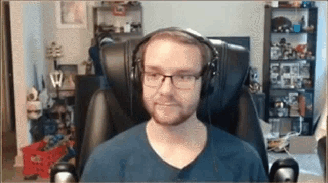 a man wearing glasses and headphones looks at the camera