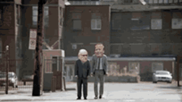 two men with masks on their faces are walking down a street .