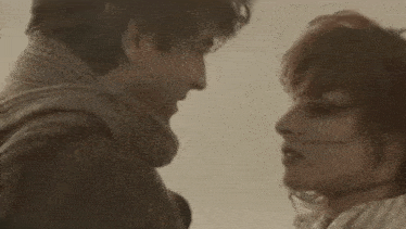 a man and a woman are looking at each other in a close up .
