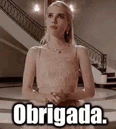 a woman in a white dress is standing in front of a staircase and a sign that says obrigada .